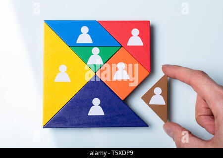 Eine Ansicht der Person Hand ein fehlendes Stück in einem quadratischen Tangram Puzzle Stockfoto