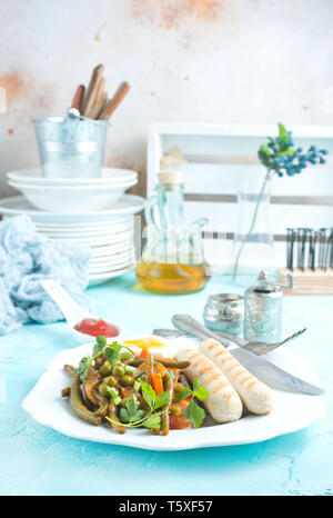 Würstchen und Gemüse für das Abendessen auf der Platte Stockfoto