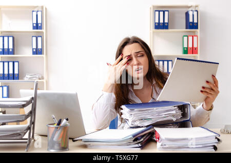 Junge weibliche Mitarbeiter mit übermäßiger Arbeit unzufrieden Stockfoto