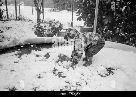 Zwei Jahre alten Baby boy in den Schnee, Medstead, Hampshire, England, Vereinigtes Königreich. Stockfoto