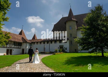 Hochzeit paar gehen Sie zu einer Kirche Foto von hinten schönes Wetter in der Schweiz Stockfoto