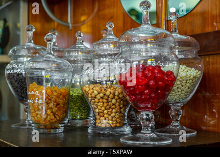 Gläser mit kandierten Kirschen, Kaffeebohnen, Orangeat, Haselnüsse, Pistazien und weiße Schokolade Stockfoto