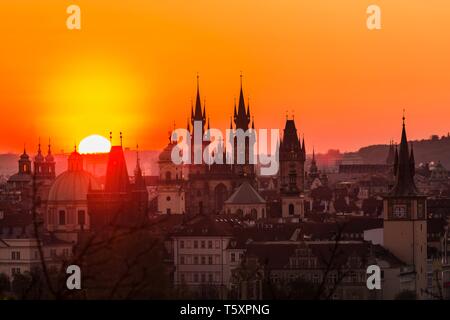 Anzeigen von orange und rosa Himmel während der morgendlichen Sonnenaufgang in Prag, Hauptstadt der Tschechischen Republik, die Sonne hinter der schwarzen Horizont scheint mit Türme und Zinnen. Stockfoto