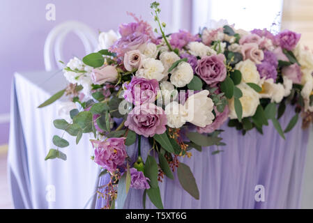 Big Band Komposition aus frischen Blumen und Grünen auf eine Tabelle der Bräutigam und die Braut. Hochzeit Floristik mit Schwerpunkt auf lila Blumen Stockfoto