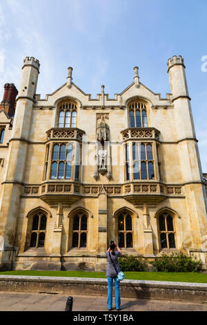 Frau ein Foto von König Henry VIII Statue, die in der Wand des Kings College, Universität Cambridge, Cambridgeshire, England Stockfoto