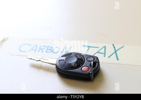 Ein Auto neben eine Notiz, die besagt, dass CO2-Steuer. Konzept der steigenden Kosten zu fahren oder die Probleme mit einer CO2-Steuer. Stockfoto