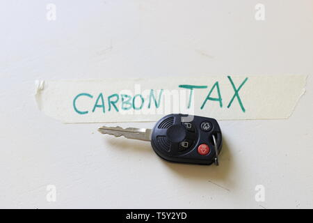 Ein Auto neben eine Notiz, die besagt, dass CO2-Steuer. Konzept der steigenden Kosten zu fahren oder die Probleme mit einer CO2-Steuer. Stockfoto