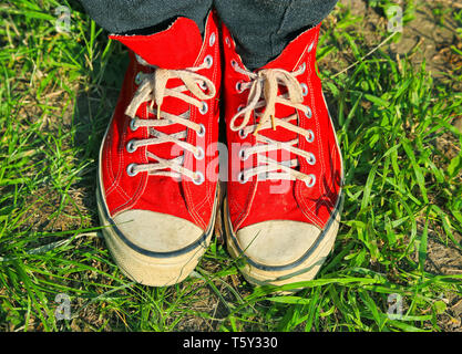 Füße in roten Sneakers in grüne Gras Stockfoto