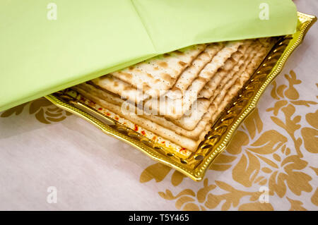 Einige Stücke matzoh, traditionelles jüdisches ungesäuertes Brot auf einem Teller mit einem grünen Serviette abgedeckt. Jüdischen Paschafest Pessach Konzept. Stockfoto