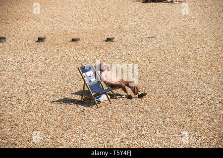 Ältere männliche Eingeschlafen beim Sonnenbaden auf einem Kiesstrand in Eastbourne East Sussex England Großbritannien Stockfoto