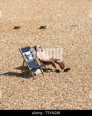 Ältere männliche Eingeschlafen beim Sonnenbaden auf einem Kiesstrand in Eastbourne East Sussex England Großbritannien Stockfoto