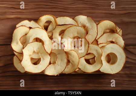 Apple Chips liegen auf einem Bambus Platte auf einem Holztisch. Nahaufnahme. Makro Stockfoto