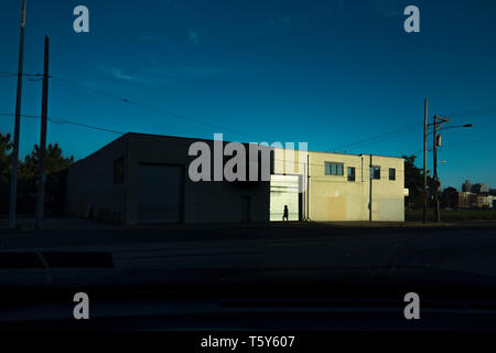 Mann vor einer Fabrik Tür am Ende des Tages Stockfoto