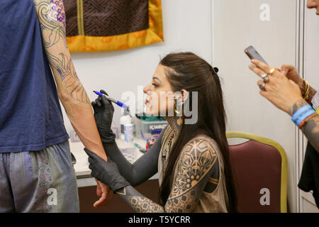 Kathmandu, Nepal. 27 Apr, 2019. Ein tattoo Artist gesehen Arbeiten an einen Kunden während der 9. Internationale Tattoo Convention. Tattoo artist aus Nepal und der ganzen Welt nehmen an den Konvent. Credit: Sunil Pradhan/SOPA Images/ZUMA Draht/Alamy leben Nachrichten Stockfoto