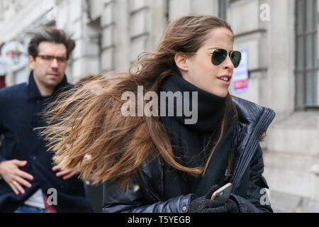 London, Großbritannien. 27. Apr 2019. Eine Frau auf dem Trafalgar Square an einem kalten und windigen Tag in London. Credit: Dinendra Haria/Alamy leben Nachrichten Stockfoto