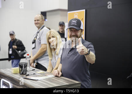 Indianapolis, Indiana, USA. 26 Apr, 2019. Film star Chuck Norris gibt einen Daumen nach oben an der Kamera, als er Autogramme Fotos an der GLOCK Pistole stand während der National Convention der National Rifle Association. Norris ist der Sprecher der Waffe. Quelle: Jeremy Hogan/SOPA Images/ZUMA Draht/Alamy leben Nachrichten Stockfoto