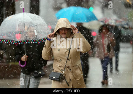 Chicago, USA. 27 Apr, 2019. Menschen gehen inmitten von Schnee in der Innenstadt von Chicago, USA, am 27. April 2019. Eine seltene spät Schneesturm fegte über Chicago am Samstag. Credit: Wang Ping/Xinhua/Alamy leben Nachrichten Stockfoto