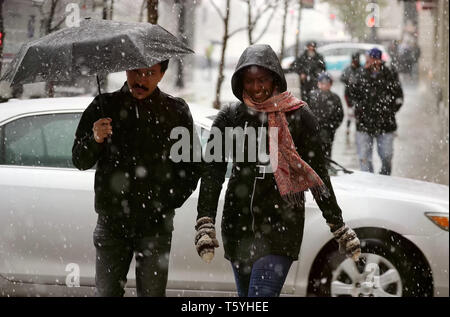 Chicago, USA. 27 Apr, 2019. Menschen gehen inmitten von Schnee in der Innenstadt von Chicago, USA, am 27. April 2019. Eine seltene spät Schneesturm fegte über Chicago am Samstag. Credit: Wang Ping/Xinhua/Alamy leben Nachrichten Stockfoto