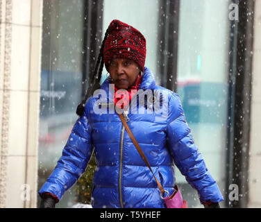 Chicago, USA. 27 Apr, 2019. Eine Dame Wanderungen inmitten von Schnee in der Innenstadt von Chicago, USA, am 27. April 2019. Eine seltene spät Schneesturm fegte über Chicago am Samstag. Credit: Wang Ping/Xinhua/Alamy leben Nachrichten Stockfoto