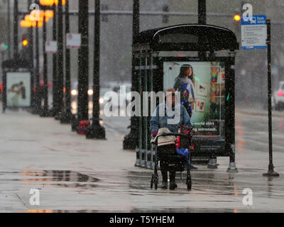 Chicago, USA. 27 Apr, 2019. Eine Dame Wanderungen inmitten von Schnee in der Innenstadt von Chicago, USA, am 27. April 2019. Eine seltene spät Schneesturm fegte über Chicago am Samstag. Credit: Wang Ping/Xinhua/Alamy leben Nachrichten Stockfoto