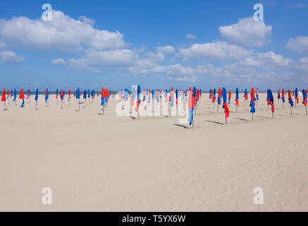 Berühmten bunten blauen und roten Sonnenschirme am Strand von Deauville, Normandie, Frankreich. Sonnenschirme am Strand von Deauville. Stockfoto