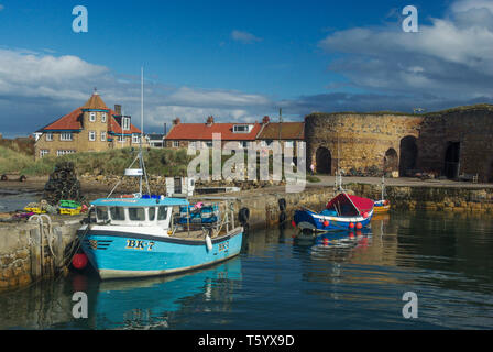 Fischerboote im Beadnell Hafen mit historischen limekilns nach hinten; Northumberland, Großbritannien Stockfoto