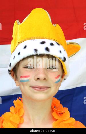 Aufgeregt Kind tragen Flagge Gesicht Farbe und eine orange Krone vor Holland Flagge Stockfoto