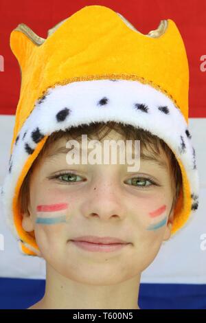 Porträt eines Kindes mit Flaggen auf ihren Wangen eine Krone trägt vor Niederlande Flagge Stockfoto