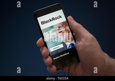 Ein Mann schaut auf seinem iPhone die zeigt die BlackRock Logo (nur redaktionelle Nutzung). Stockfoto