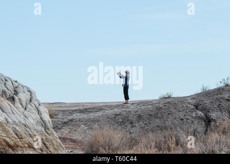 Drumheller, Alberta/Kanada - 17. April 2019: Leute um Suspension Bridge wandern, die in der Red Deer River in Drumheller, Alberta, Kanada, Alberta, Tourismus geht Stockfoto