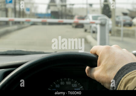 Close Up, die Hand der Fahrer des Autos auf dem Hintergrund einer geschlossenen Schranke zum Parkplatz des geschützten Objekts eingeben Stockfoto