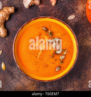 Kürbis und Karotten Suppe serviert mit Samen, Ansicht von oben. Stockfoto