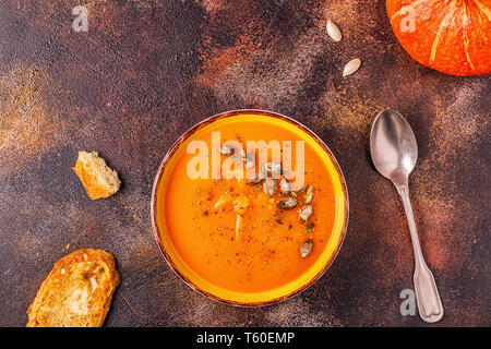 Kürbis und Karotten Suppe serviert mit Samen, Ansicht von oben. Stockfoto