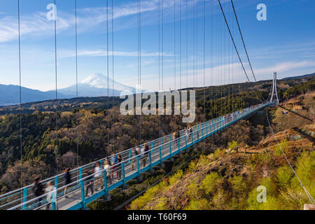 Menschen walkin auf Mishima Skywalk Brücke mit Mount Fuji, die in der fernen, sonnigen Tag gesehen Stockfoto