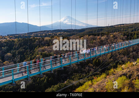Menschen walkin auf Mishima Skywalk Brücke mit Mount Fuji, die in der fernen, sonnigen Tag gesehen Stockfoto