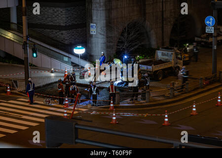 Odaiba, Japan - 9. April 2019 - am Straßenrand Bauarbeiter fix Bürgersteig in der Nacht in Odaiba, Japan in der Nacht vom 9. April 2019 Stockfoto