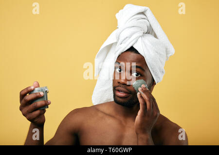 Wunderschöne Mann kümmert sich von seinem Gesicht, indem Sie die Creme auf seinem Gesicht. Bis portrait schließen. Stockfoto