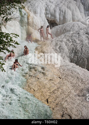 Bagni San Filippo, Italien - 24 April 2019: Menschen Ruhe auf den thermischen Salz Wasserfälle der Mineralquellen von Bagni San Filippo an einem sonnigen Tag. Stockfoto