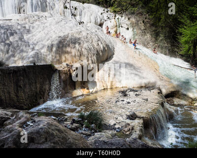 Bagni San Filippo, Italien - 24 April 2019: Menschen Ruhe auf den thermischen Salz Wasserfälle der Mineralquellen von Bagni San Filippo an einem sonnigen Tag. Stockfoto