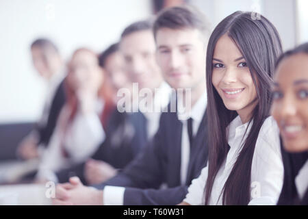 Business-Leute sitzen in einer Reihe und arbeiten, Fokus auf hübsche Frau Stockfoto