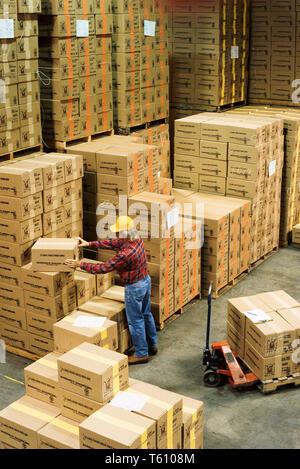 Männlicher Arbeiter, der Inventar in einem Industrielager, USA, 1992 Stockfoto