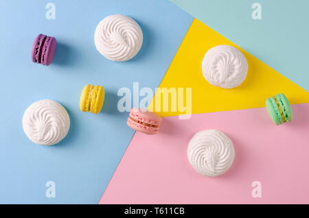Süße bunte Makronen oder Macarons auf bunten Pastellfarben geometrischen Hintergrund. Kopieren Sie Platz. Französische dessert Konzept. Keine Diät Tag Stockfoto