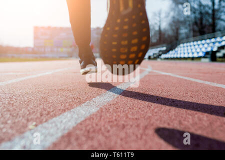 Foto von hinten in der Nähe der Füße des Athleten laufen um Stadion Frühling Stockfoto