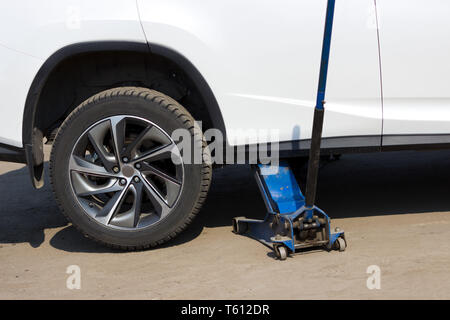 Frühjahr Reifen anbringen. Austausch verzierte Räder mit herkömmlichen. Die Buchse auf der anderen Seite hebt das Auto und das Rad ist es entfernt Stockfoto