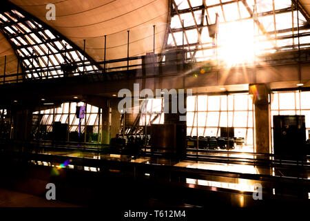 Silhouette der Suvarnabhumi Airport (VTBS) Passagier Terminal an einem sonnigen Tag mit Sunburst durch das Glasdach Stockfoto