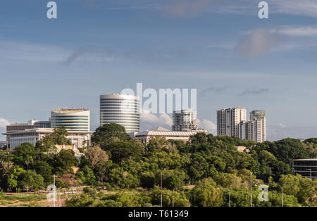 Darwin Australien - Februar 22, 2019: Südseite Bürotürme in der Innenstadt hinter grünen Zone holding Regierung Haus angrenzenden Hafen unter blauen Himmel Stockfoto