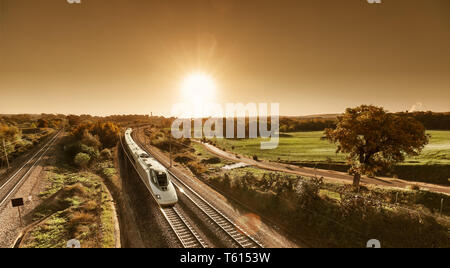 High speed Weiß der Zug nähert sich durch die Landschaft. Stockfoto