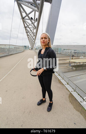 Schöne Fitness Frau Läufer stehen auf moderne Brücke in der Stadt Stockfoto