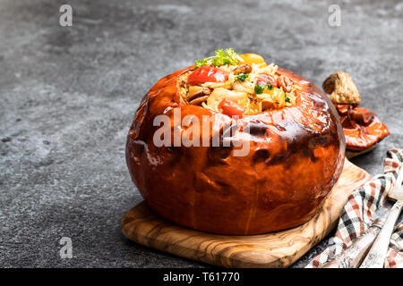 Gebackener Kürbis gefüllt mit Reis und Huhn auf dem Tisch Stockfoto