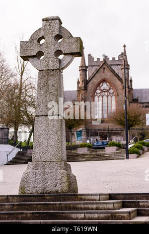 Irische Stein keltisches Kreuz im Armagh Marktplatz mit Saint Patrick's Kirche von Irland hinter sich. Stockfoto